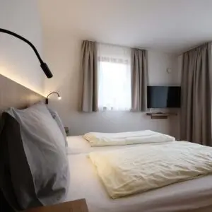 Das Schlafzimmer der Ferienwohnung "klein und fein" im Seehotel Kärntnerhof am Weissensee.