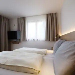 Schlafzimmer der Ferienwohnung Seezauber im Seehotel Kärntnerhof am Weissensee.